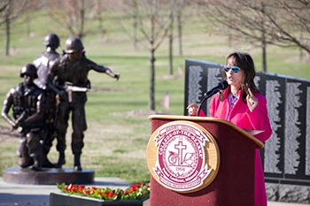 Woman speaking in front of war memorial